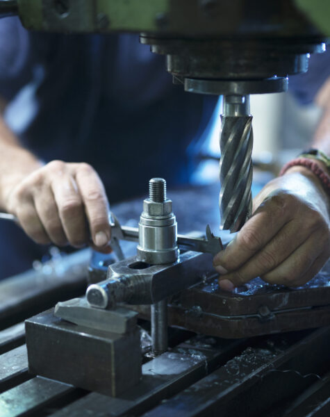 Worker operating industrial machine in metal workshop. Worker operating industrial machine in metal workshop.